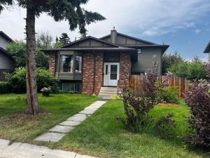 a house with a tree in the yard at Biddington private room close airport! in Calgary