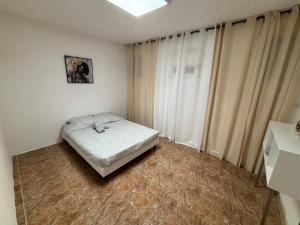 a small bedroom with a bed and a window at T2 ZEN Climatisé à Acajou Lamentin in Le Lamentin