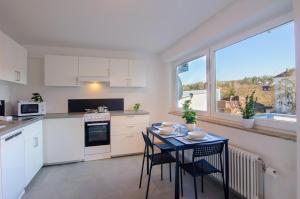 a kitchen with white cabinets and a table with chairs at MZK Maier Schnäppchen im Zentrum in Pforzheim