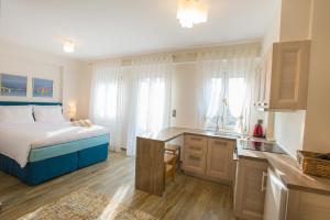 a bedroom with a bed and a desk and a kitchen at Villa Vilielmini in Ioannina