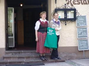 Duas mulheres à porta de um edifício com um saco. em Kronenwirt em Gurk