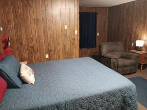 una camera da letto con un letto e una sedia in una stanza di Crawford Motel a Springfield Altre 7 foto
