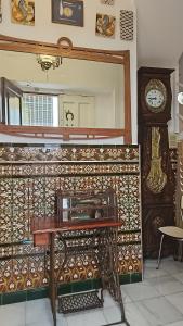 een spiegel en een tafel en een klok in een kamer bij Recuerdos de la Abuela in Sevilla