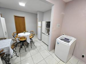 a kitchen and dining room with a table and a washing machine at Central House in Itajaí