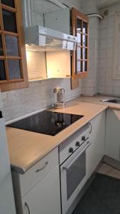 een keuken met een spoelbak en een fornuis bovenste oven bij Apartamento Grau de Gandía in Gandía