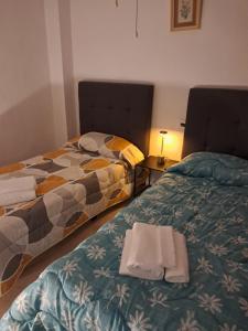 een hotelkamer met twee bedden met handdoeken erop bij Apartamento Grau de Gandía in Gandía