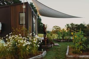 KanimblaKanimbla Sunsets by Tiny Away的站在鲜花屋外的人