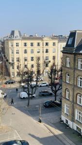 a large building with cars parked in a parking lot at ApartmentInCopenhagen Apartment 1676 in Copenhagen