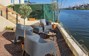 a group of chairs and a fire pit next to the water at Awesome Home In Milly-Sur-Thérain in Milly-sur-Thérain