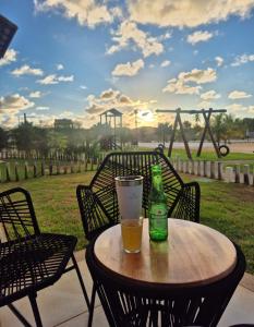 a beer bottle and a glass on a wooden table at Apto PDI na praia em Baixio in Baixio