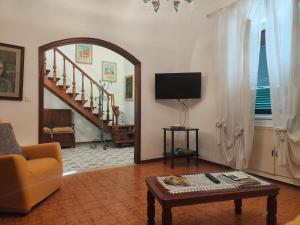 a living room with a couch a table and a tv at Holiday Home Camaiore near Lido Beaches in Camaiore
