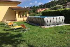 a group of chairs and a pool in a yard at Holiday Home Camaiore near Lido Beaches in Camaiore