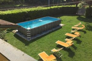 a swimming pool with lounge chairs and a group at Holiday Home Camaiore near Lido Beaches in Camaiore