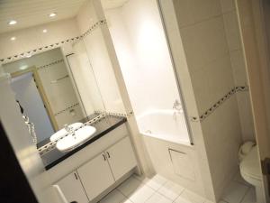 a bathroom with a sink and a tub and a toilet at Villa Apartment with Terrace in Durbuy