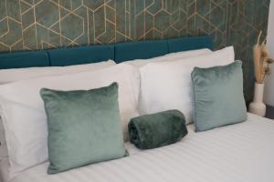 ウォルヴァーハンプトンにあるPARKING & BALCONY Luxe City Centre Sleeps 4の白い枕と緑の枕が2つ置かれたベッド +14枚の写真