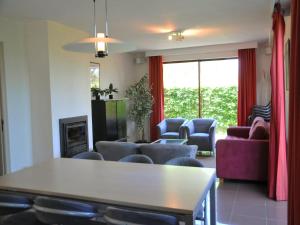 a living room with a table and chairs at Apt w Fireplace & Garden in Durbuy