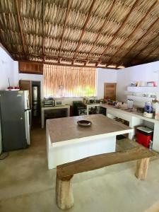 a large kitchen with a table and a refrigerator at la casablanca moñitos in Moñitos