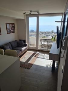 a living room with a couch and a large window at Departamento Familiar con vista al Mar in Viña del Mar