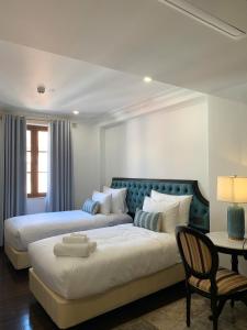 een slaapkamer met 2 bedden en een tafel met een stoel bij The Room Hotel - Starbucks in Phu Quoc +64 foto's