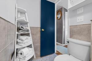 a bathroom with a white toilet and a blue door at Cozy apartment, private beach & jacuzzi in Westbrook +11 photos