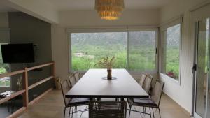 a dining room with a table and chairs and a large window at La Deseada in Quines