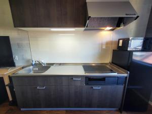 a small kitchen with a sink and a microwave at 古都ひかり3 in Takayama