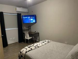 a bedroom with a bed and a desk and a tv at LiV109 Norte Depa 2 Cd Obregon in Ciudad Obregón
