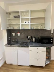 メンヒェングラートバッハにあるStilvolles Studio Apartment im Zentrum MGの白いキャビネットとシンクのあるキッチン +7枚の写真