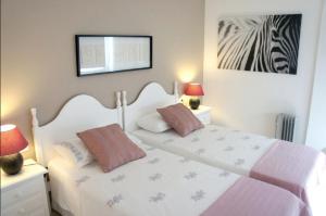 una camera con un letto bianco con due cuscini di Departamento Corriquia a Playa Blanca
