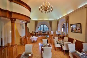 a restaurant with tables and chairs and a chandelier at Questenberg Hotel in Prague