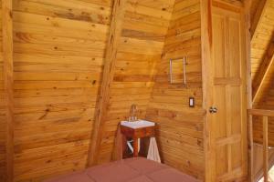 a bathroom with a sink in a wooden wall at Chalet in San Pedro