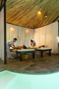 a group of people laying on beds in a room at Panorama Boutique Hotel & Beach Club in El Nido