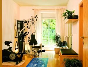 a room with a gym with exercise equipment and a window at Hotel Filipinum in Merano