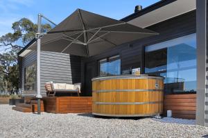 a house with a wooden barrel and an umbrella at Warrawindi Escapes in Penola