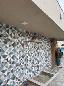 pared de azulejos en un edificio con escaleras en DiRoma Fiori Caldas Novas - YMT - 030, en Caldas Novas