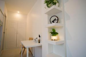 a white dining room with a table and shelves at Place Hotel in Kata Beach