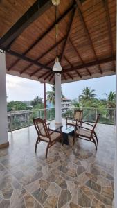 un patio con 2 sillas, una mesa y un banco en Sunsusi Apartments and Tourist Rest, en Aluthgama