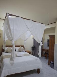 a bedroom with two beds with white drapes at Kelle Homestay in Sidemen +9 photos