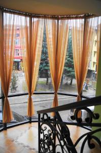 - une fenêtre avec des rideaux orange et une vue sur une rue dans l'établissement Villa Sofia, à Trouskavets