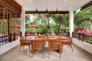 an outdoor dining room with a wooden table and chairs at The Magic Villa Keramas in Gianyar