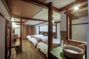 a room with three beds and a sink in it at 张家界畔山驿栈 in Zhangjiajie