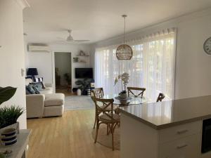 a kitchen and living room with a table and chairs at Headlands at Black Head in Hallidays Point