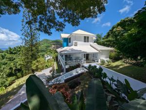a white house on a hill with trees at Paradise Haven Saint Lucia in Corinthe
