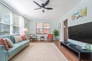 a living room with a couch and a flat screen tv at Beachy Bungalow at Jacksonville in Jacksonville
