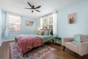 a bedroom with a bed and a chair at Beachy Bungalow at Jacksonville in Jacksonville