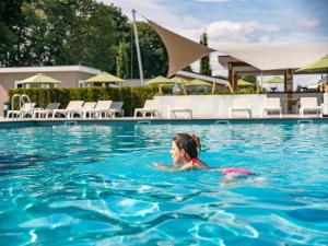 a woman in the swimming pool at a resort at Holiday Home Bemelen near Bemelerberg Reserve in Bemelen