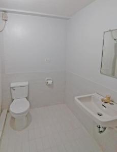 a white bathroom with a toilet and a sink at Doña Mercedes in Cebu City +25 photos