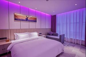 a bedroom with a large bed and purple lighting at Paco Hotel Guangzhou Baiyun Airport Liantang Metro in Huadu