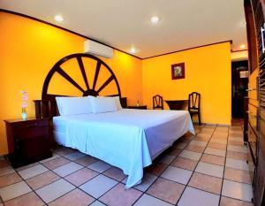 a bedroom with a large bed and yellow walls at Hotel Esmeralda in Poza Rica de Hidalgo