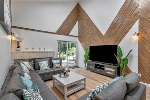 Una sala de estar con un sofá y un televisor de pantalla plana. en Tropical Bliss - 5BR Pool Spa Games 12 min to dwtn, en San Diego